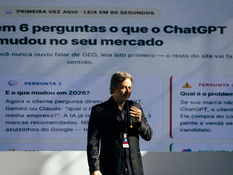 Alexandre Caramaschi num palco, diante de um telão com a página do site Entenda em 6 perguntas o que o ChatGPT mudou no seu mercado.